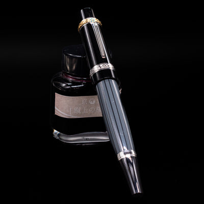 Montblanc Writer's Edition Honore de Balzac Fountain Pen - Preowned capped, leaning against an ink bottle. 