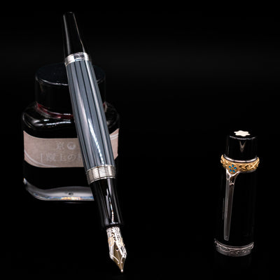 Montblanc Writer's Edition Honore de Balzac Fountain Pen - Preowned leaning on an ink bottle uncapped showcasing the detailing on the nib.