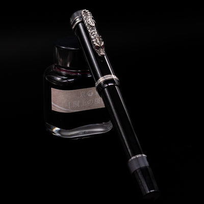 Montblanc Writer's Edition Imperial Dragon 1993 Fountain Pen - Preowned capped, leaning against an ink bottle. 
