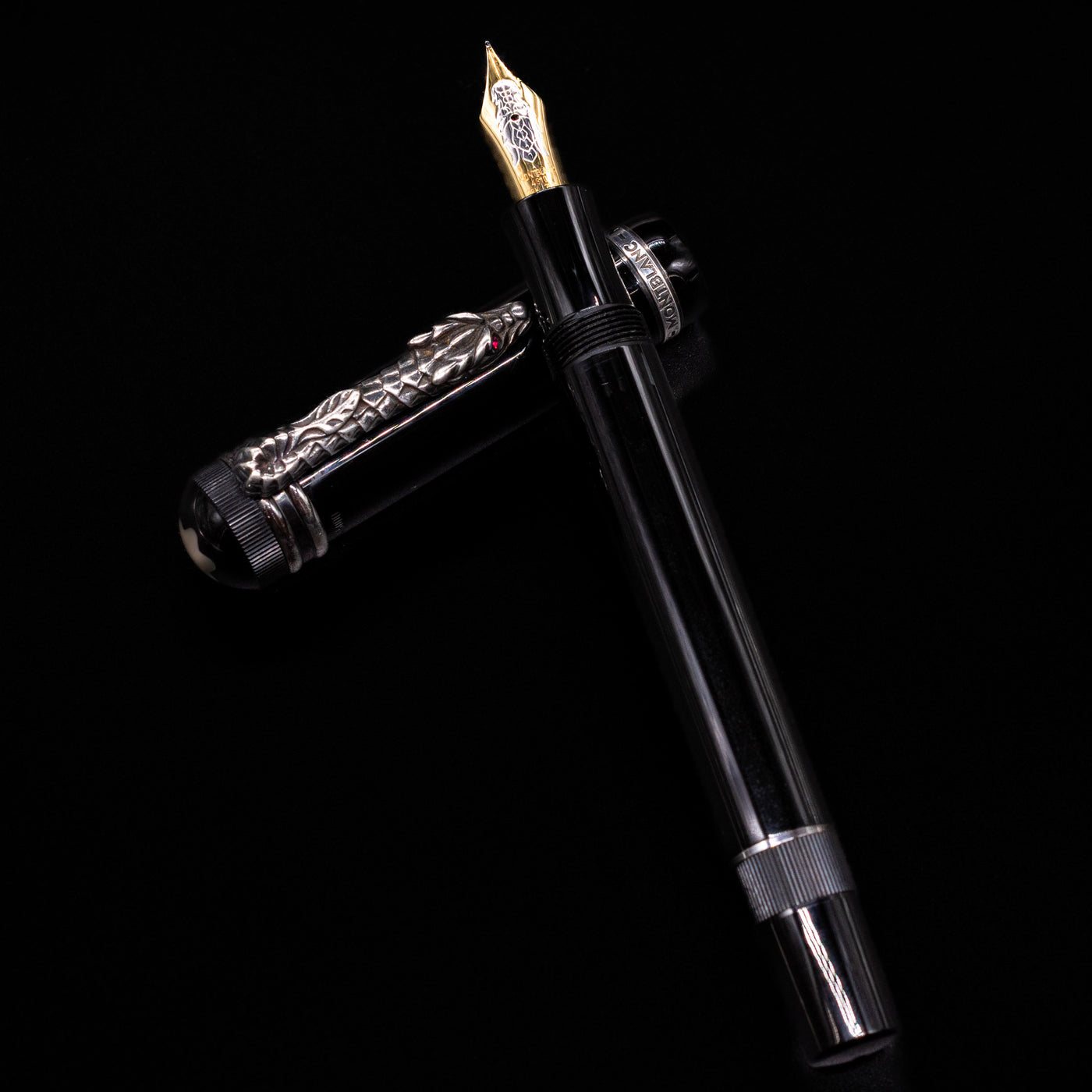 Montblanc Writer's Edition Imperial Dragon 1993 Fountain Pen - Preowned laying on top of its cap in a crossed position showing full view of the entire uncapped pen.