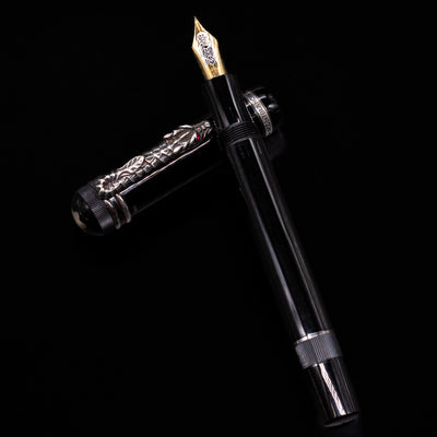 Montblanc Writer's Edition Imperial Dragon 1993 Fountain Pen - Preowned laying on top of its cap in a crossed position showing full view of the entire uncapped pen.