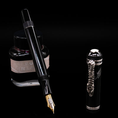 Montblanc Writer's Edition Imperial Dragon 1993 Fountain Pen - Preowned leaning on an ink bottle uncapped showcasing the detailing on the nib.