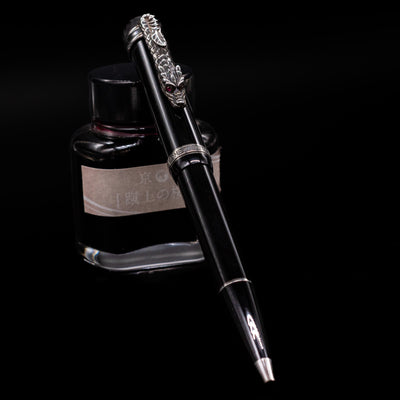 Montblanc Writer's Edition Imperial Dragon Ballpoint Pen - Preowned leaning against an ink bottle.