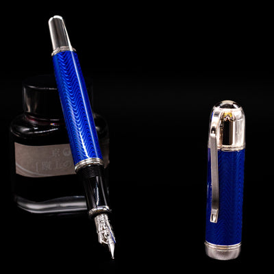 Montblanc Writer's Edition Jules Verne Fountain Pen - Preowned leaning on an ink bottle uncapped showcasing the detailing on the nib.