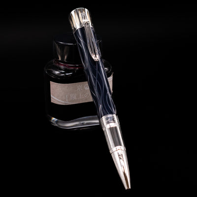 Montblanc Writer's Edition Mark Twain Ballpoint Pen - Preowned leaning against an ink bottle.