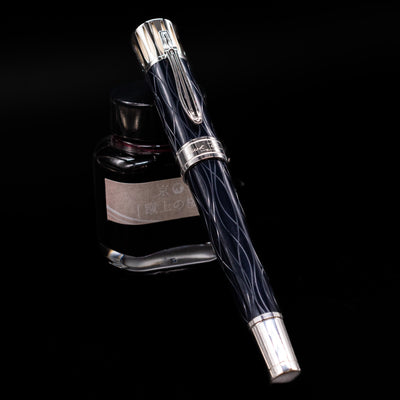Montblanc Writer's Edition Mark Twain Fountain Pen - Preowned capped, leaning against an ink bottle. 