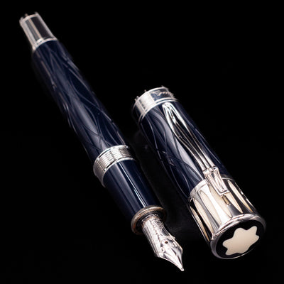 A full view of the Montblanc Writer's Edition Mark Twain Fountain Pen - Preowned uncapped, with its cap laying next to the pen.