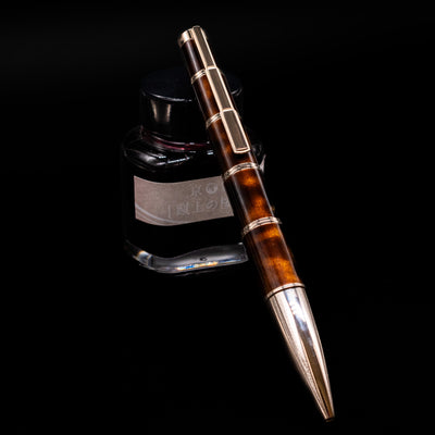 Montblanc Writer's Edition Miguel de Cervantes Ballpoint Pen - Preowned leaning on an ink bottle.