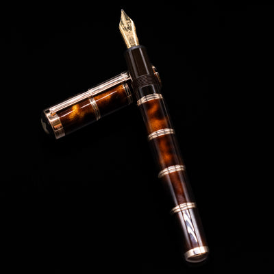 Montblanc Writer's Edition Miguel de Cervantes Fountain Pen - Preowned laying on top of its cap in a crossed position showing full view of the entire uncapped pen.