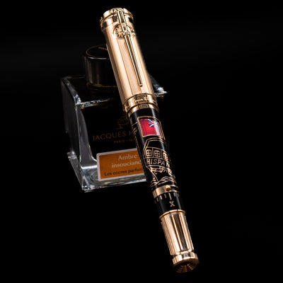 Montblanc Writer's Edition Robert Louis Stevenson Limited Edition 1833 Rollerball Pen - Preowned capped, leaning against an ink bottle. 