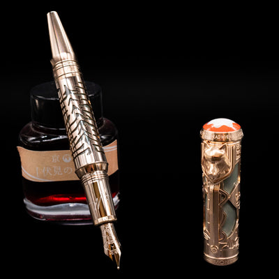 Montblanc Writer's Edition Rudyard Kipling 1895 Fountain Pen - Preowned leaning on an ink bottle uncapped showcasing the detailing on the nib.