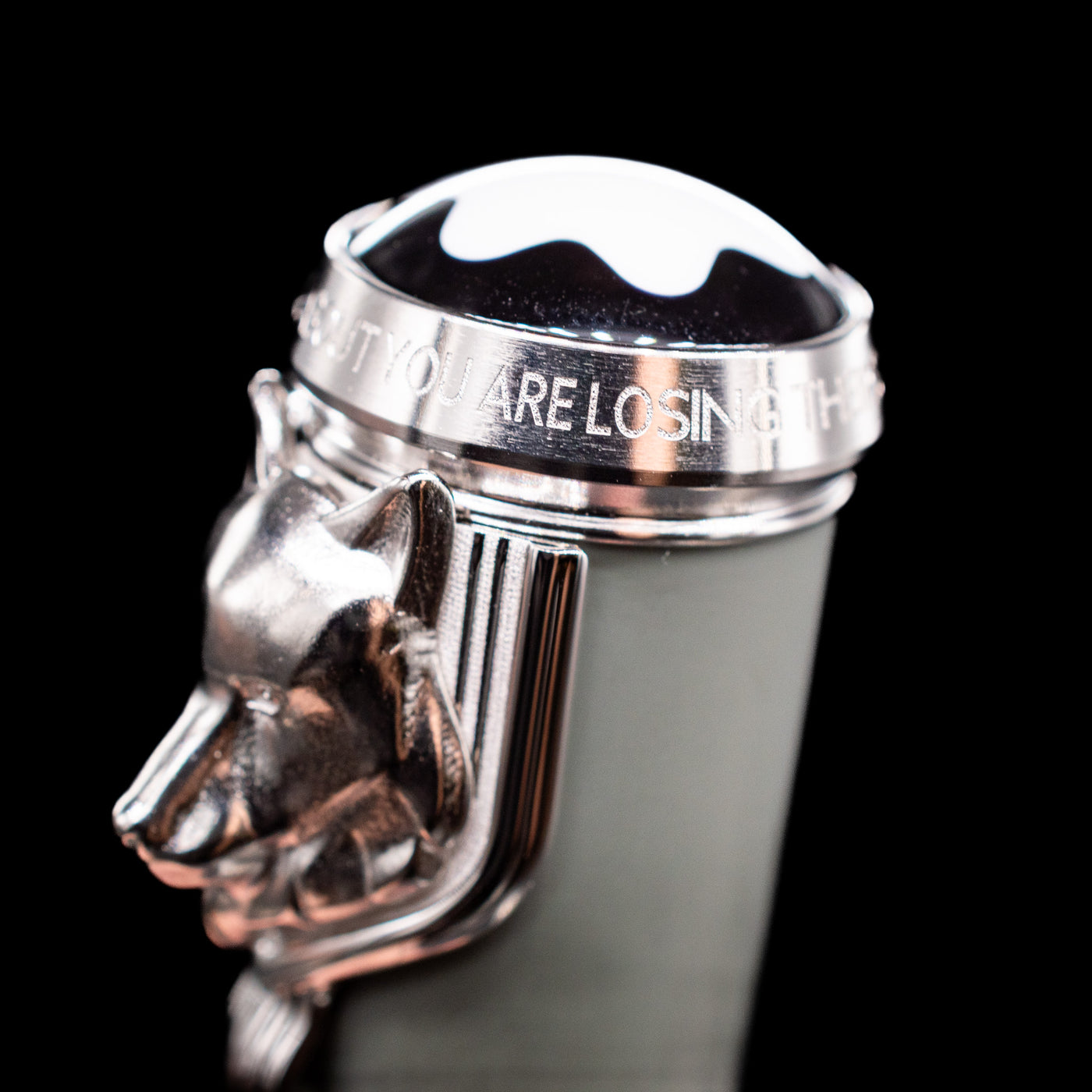 A macro shot of the wolf on the clip and the word saying on top of the cap on the Montblanc Writer's Edition Rudyard Kipling Ballpoint Pen - Preowned.