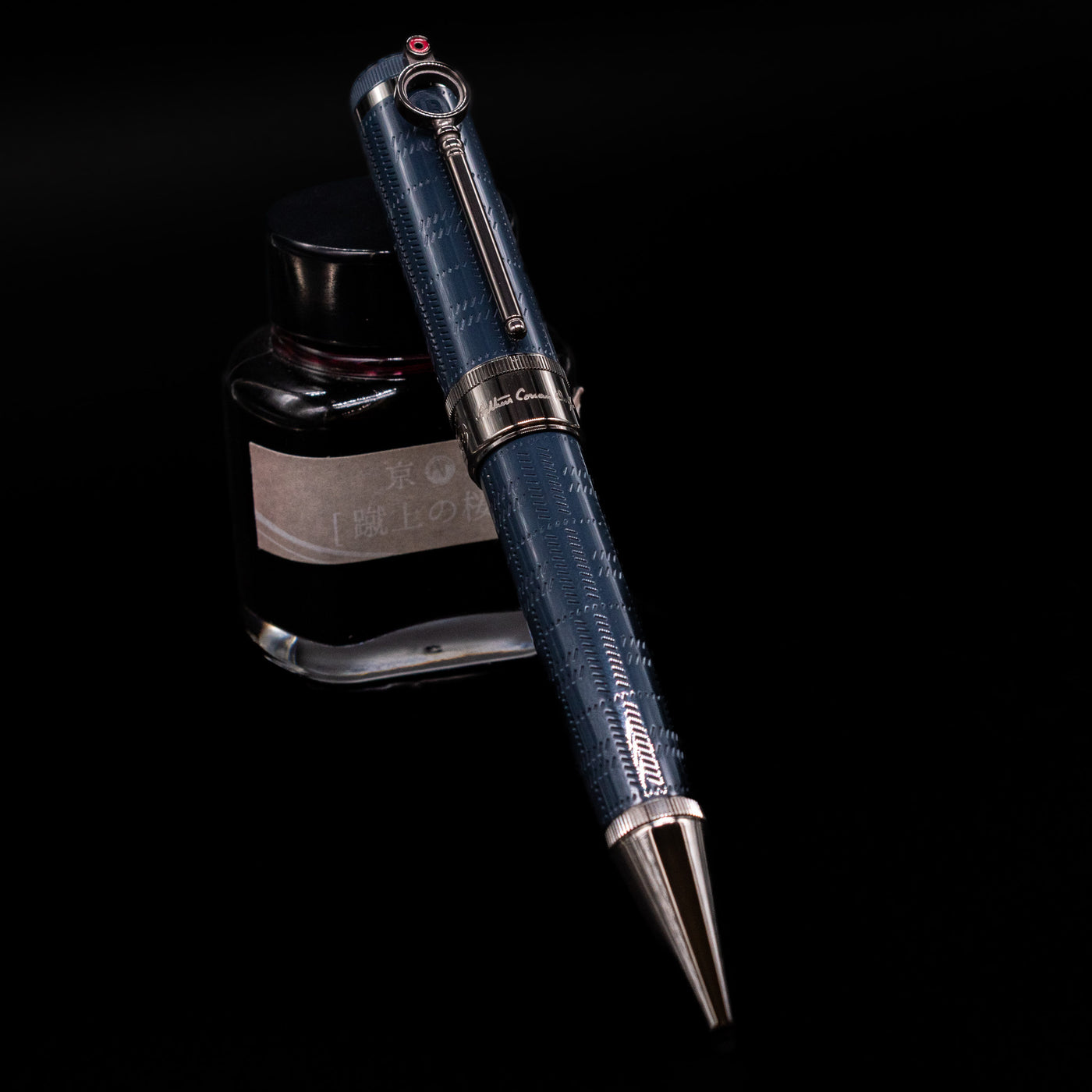 Montblanc Writer's Edition Sir Arthur Conan Doyle Ballpoint Pen - Preowned leaning against an ink bottle.
