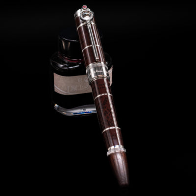 Montblanc Writer's Edition Sir Arthur Conan Doyle Limited Edition 1902 Rollerball Pen - Preowned capped, leaning against an ink bottle. 