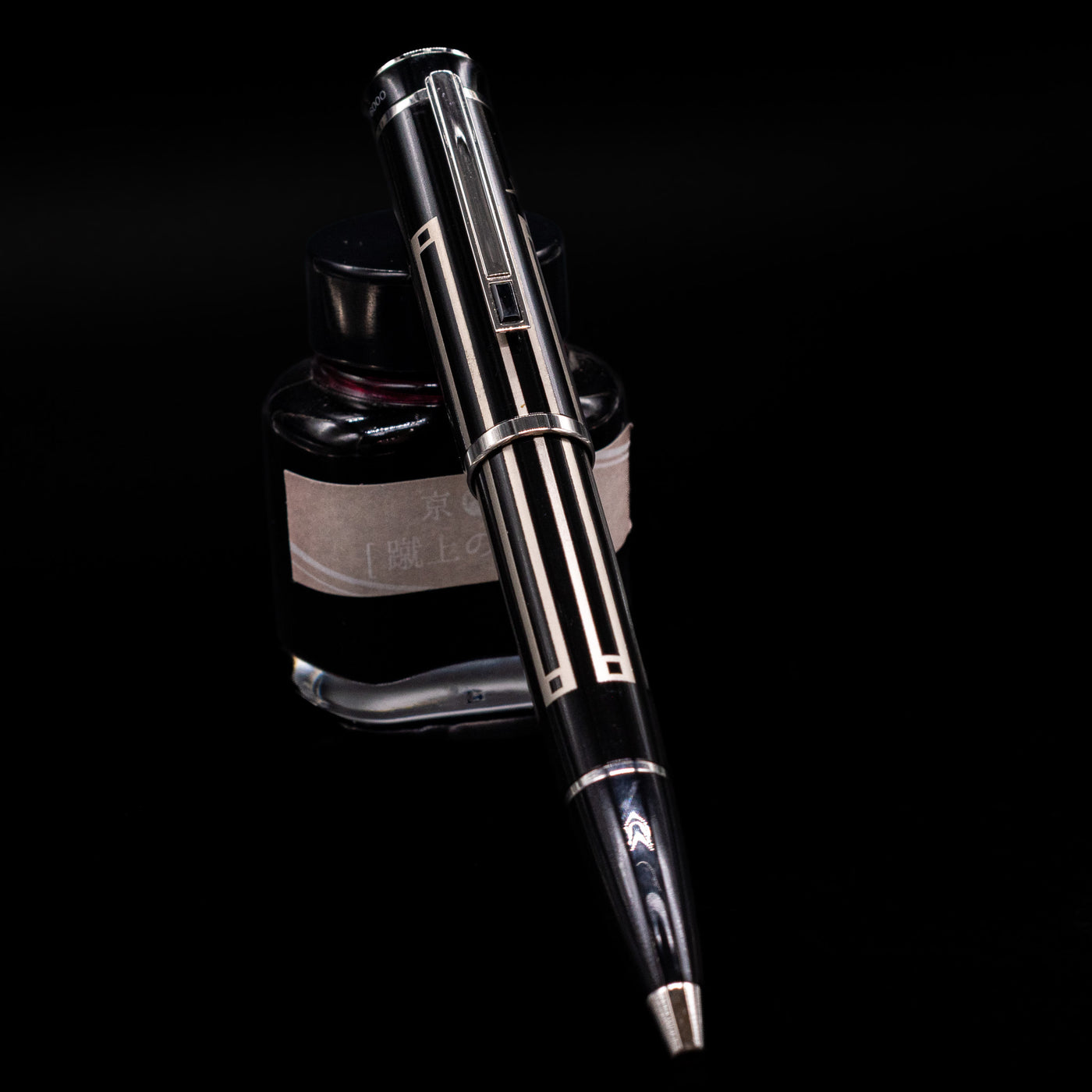 Montblanc Writer's Edition Thomas Man Ballpoint Pen - Preowned leaning on an ink bottle.