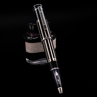 Montblanc Writer's Edition Thomas Man Ballpoint Pen - Preowned leaning on an ink bottle.