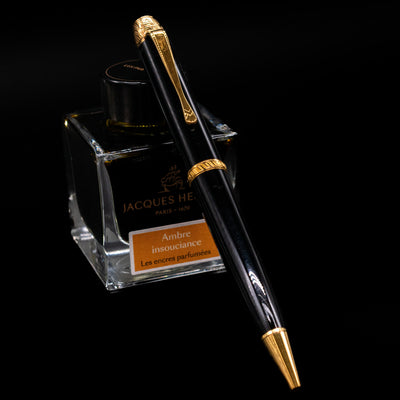 Montblanc Writer's Edition Voltaire Ballpoint Pen - Preowned leaning on an ink bottle.