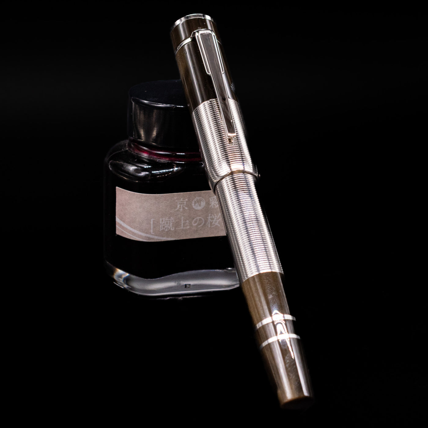 Montblanc Writer's Edition William Faulkner Fountain Pen - Preowned  capped, leaning against an ink bottle. 