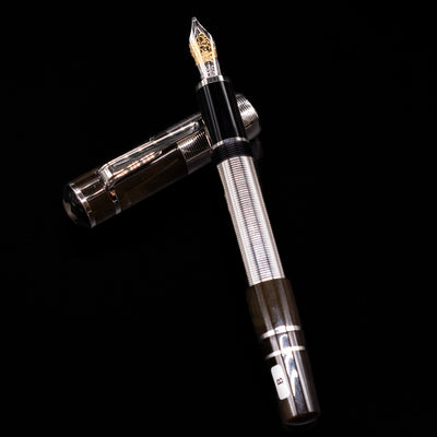 Montblanc Writer's Edition William Faulkner Fountain Pen - Preowned  laying on top of its cap in a crossed position showing full view of the entire uncapped pen.