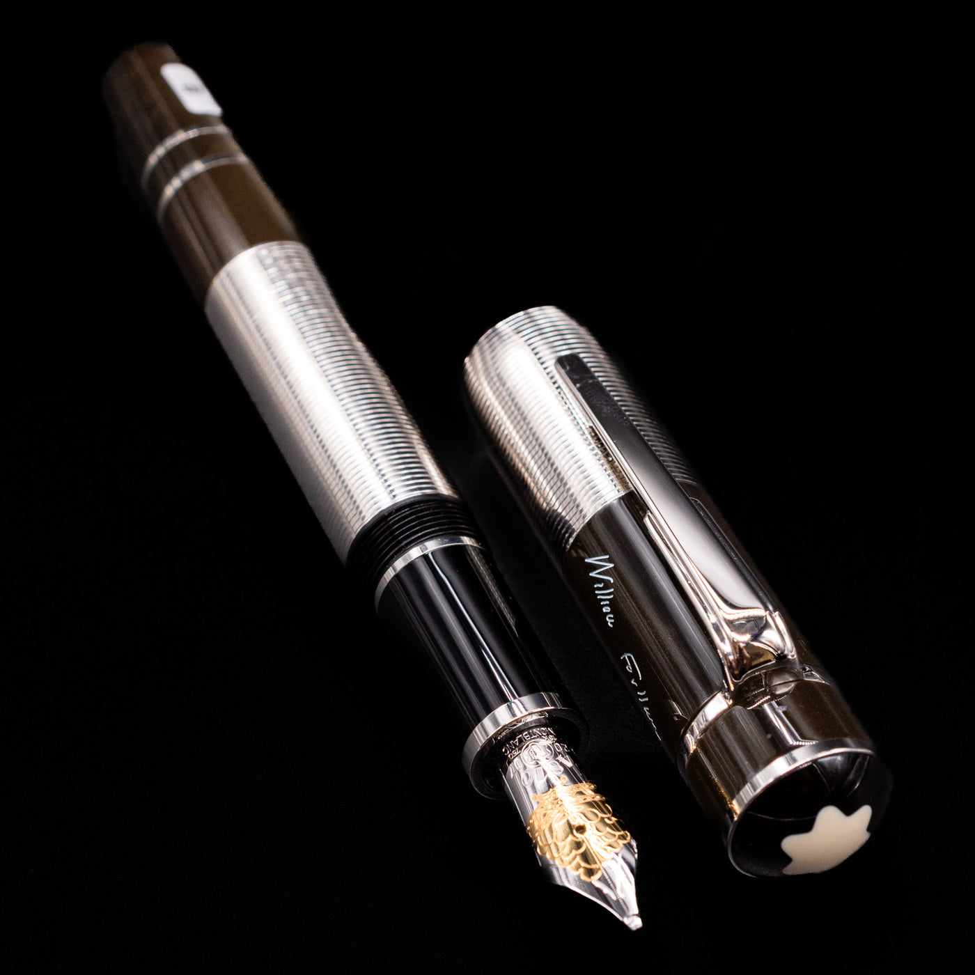 A full view of the Montblanc Writer's Edition William Faulkner Fountain Pen - Preowned uncapped, with its cap laying next to the pen. 
