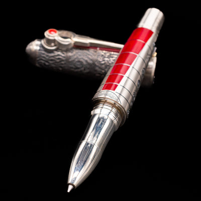 Montegrappa Alchemist Ignis Rollerbal Pen laying across its own cap, crossed, with a focus on the tip.