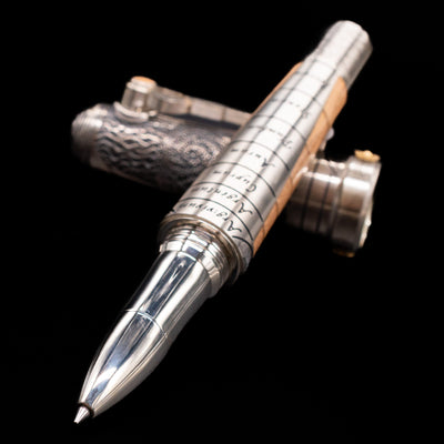 Montegrappa Alchemist Terra Rollerball Pen laying across its own cap, crossed, with a focus on the tip.