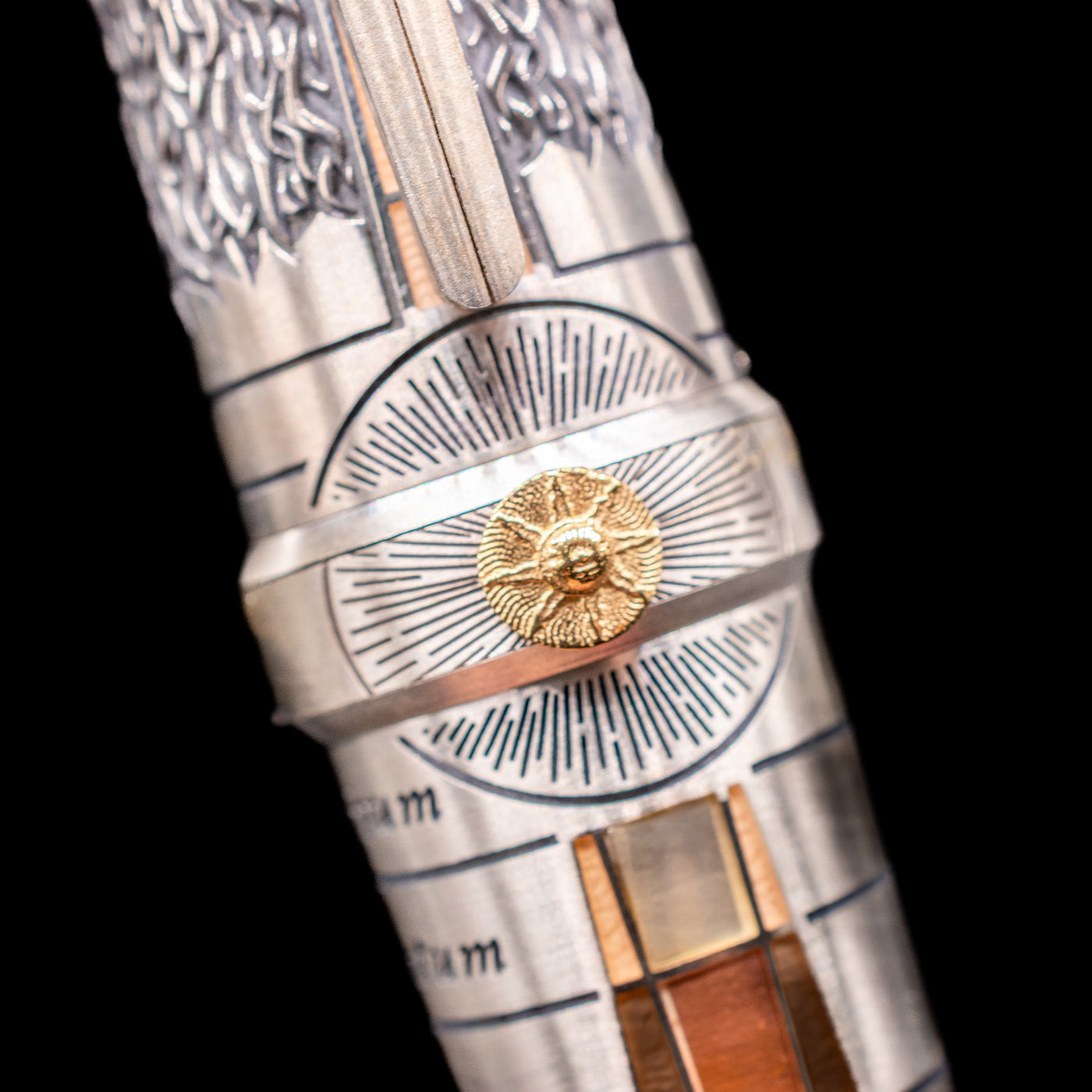 A detail shot of the sun on the middle ring of the body of the Montegrappa Alchemist Terra Rollerball Pen.