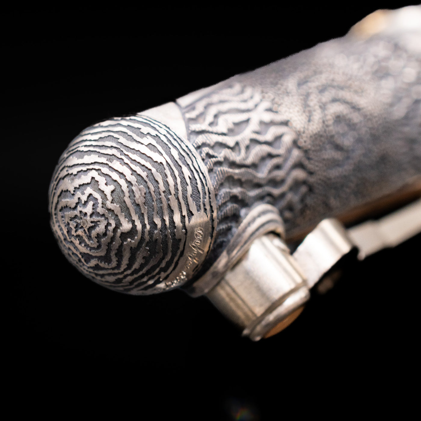 Zoomed-in view of the top of the cap with the finial on the Montegrappa Alchemist Terra Rollerball Pen.
