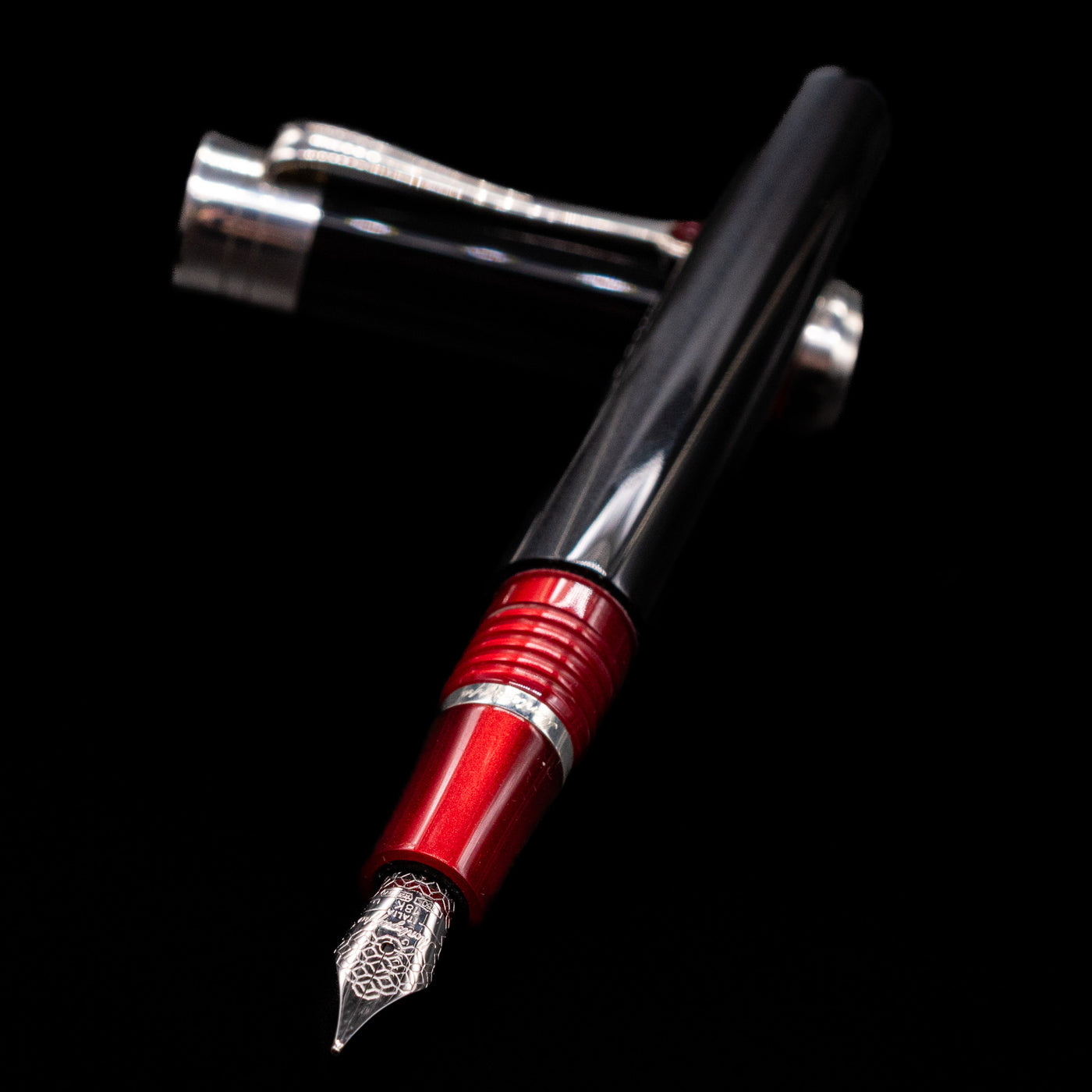Montegrappa Desiderio Black Fountain Pen - Preowned laying across its own cap, crossed, with a focus on the nib.