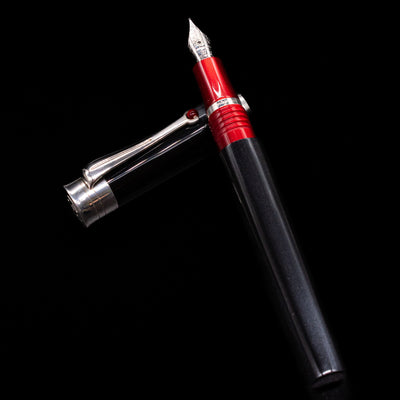 Montegrappa Desiderio Black Fountain Pen - Preowned laying on top of its cap in a crossed position showing full view of the entire uncapped pen.