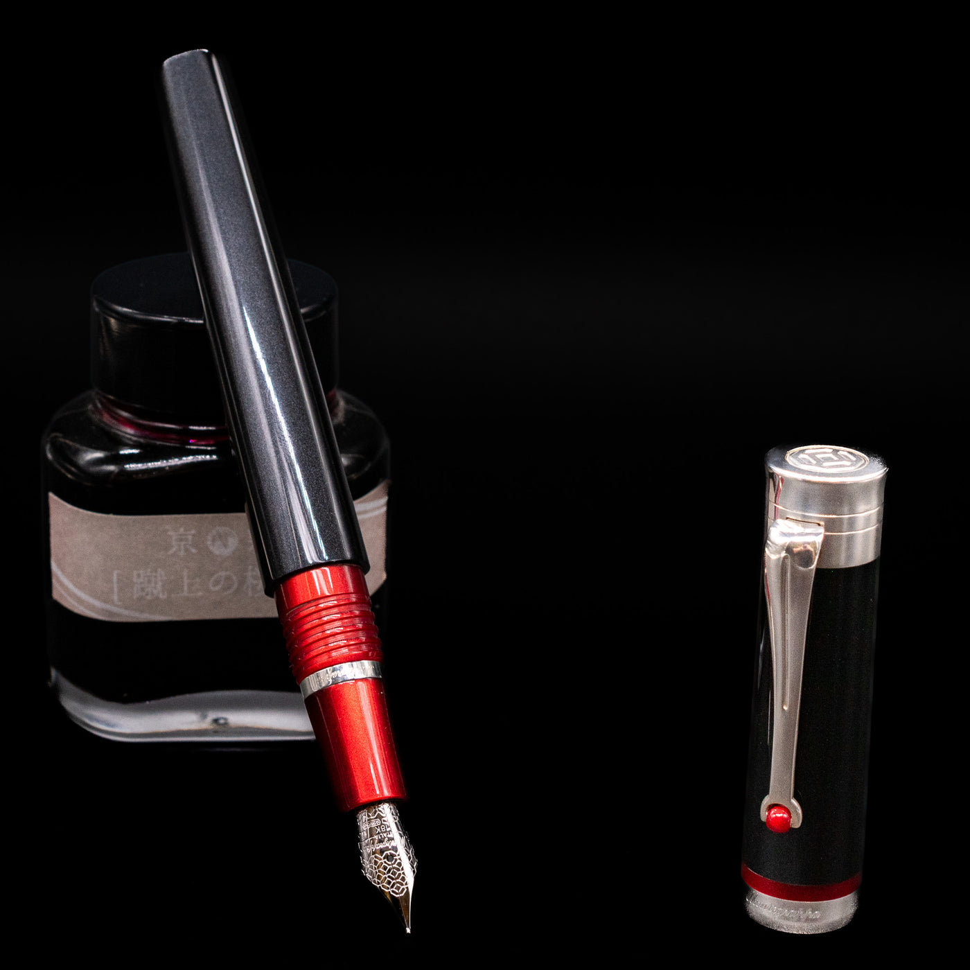 Montegrappa Desiderio Black Fountain Pen - Preowned leaning on an ink bottle uncapped showcasing the detailing on the nib.