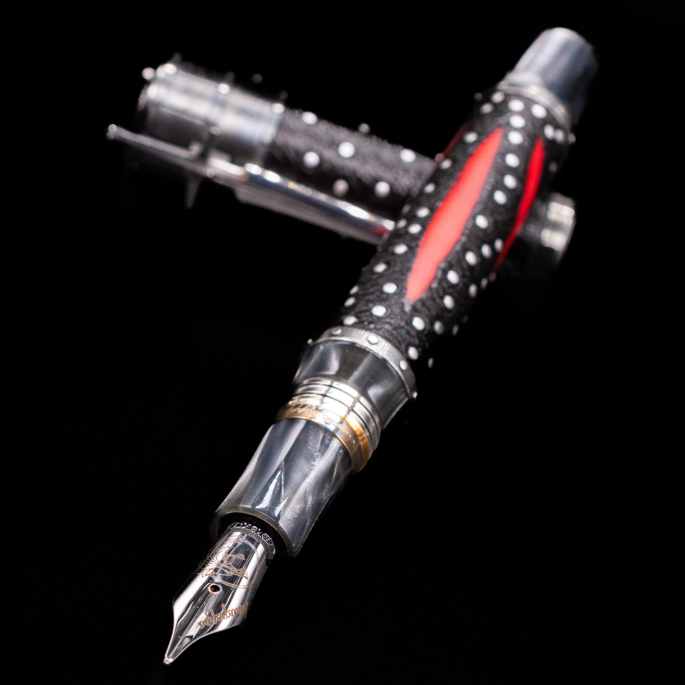 Montegrappa The Witcher: Mutation Fountain Pen laying across its own cap, crossed, with a focus on the nib.