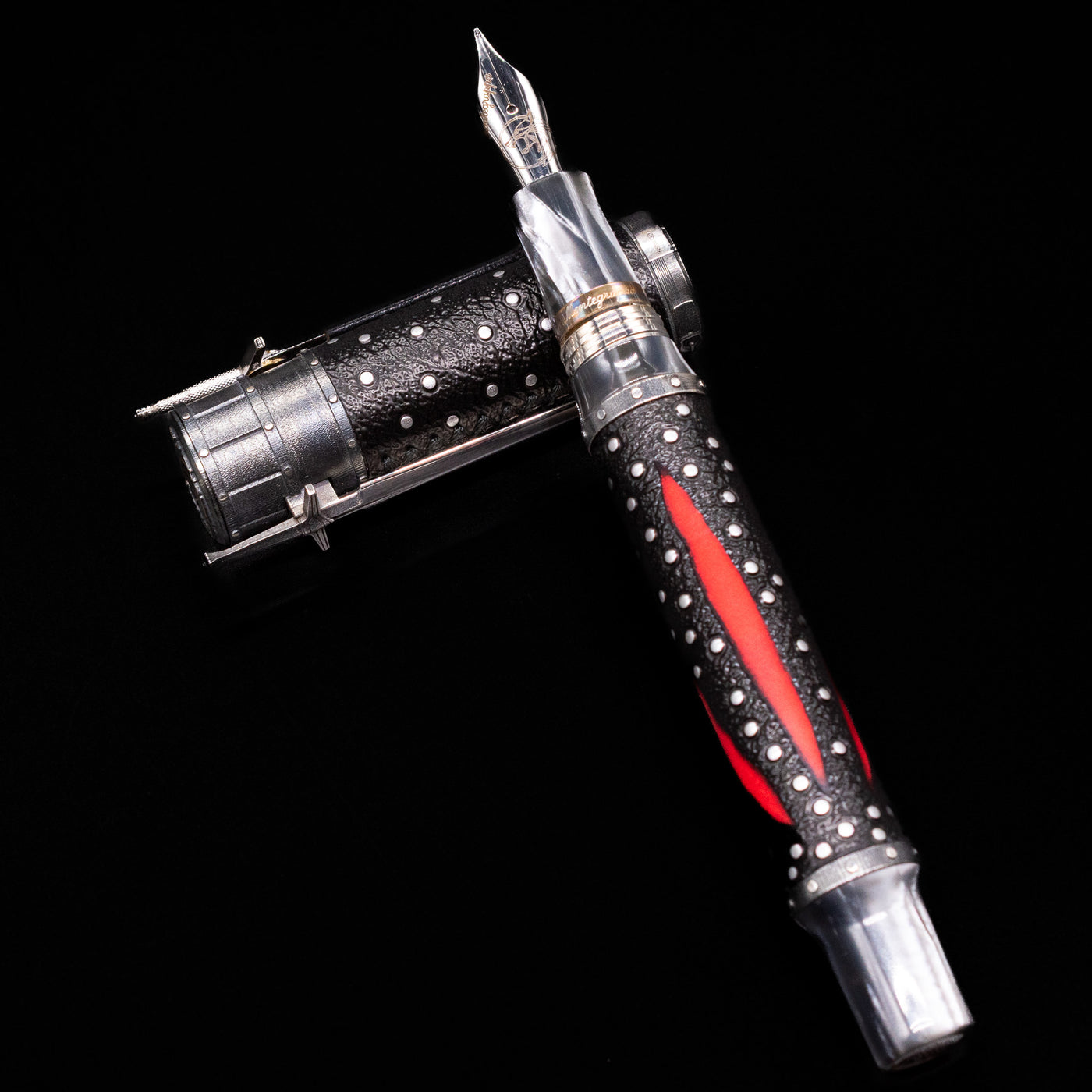 Montegrappa The Witcher: Mutation Fountain Pen laying on top of its cap in a crossed position showing full view of the entire uncapped pen.