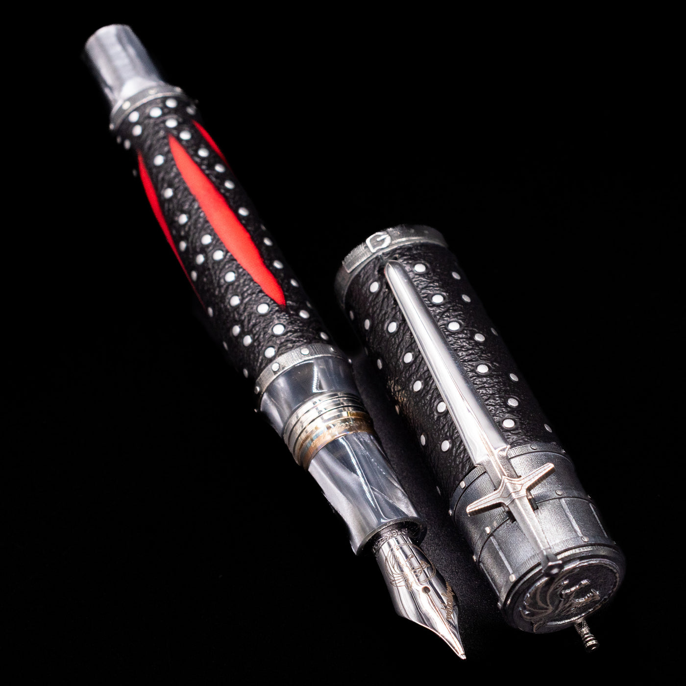  A full view of the Montegrappa The Witcher: Mutation Fountain Pen uncapped, with its cap laying next to the pen. 