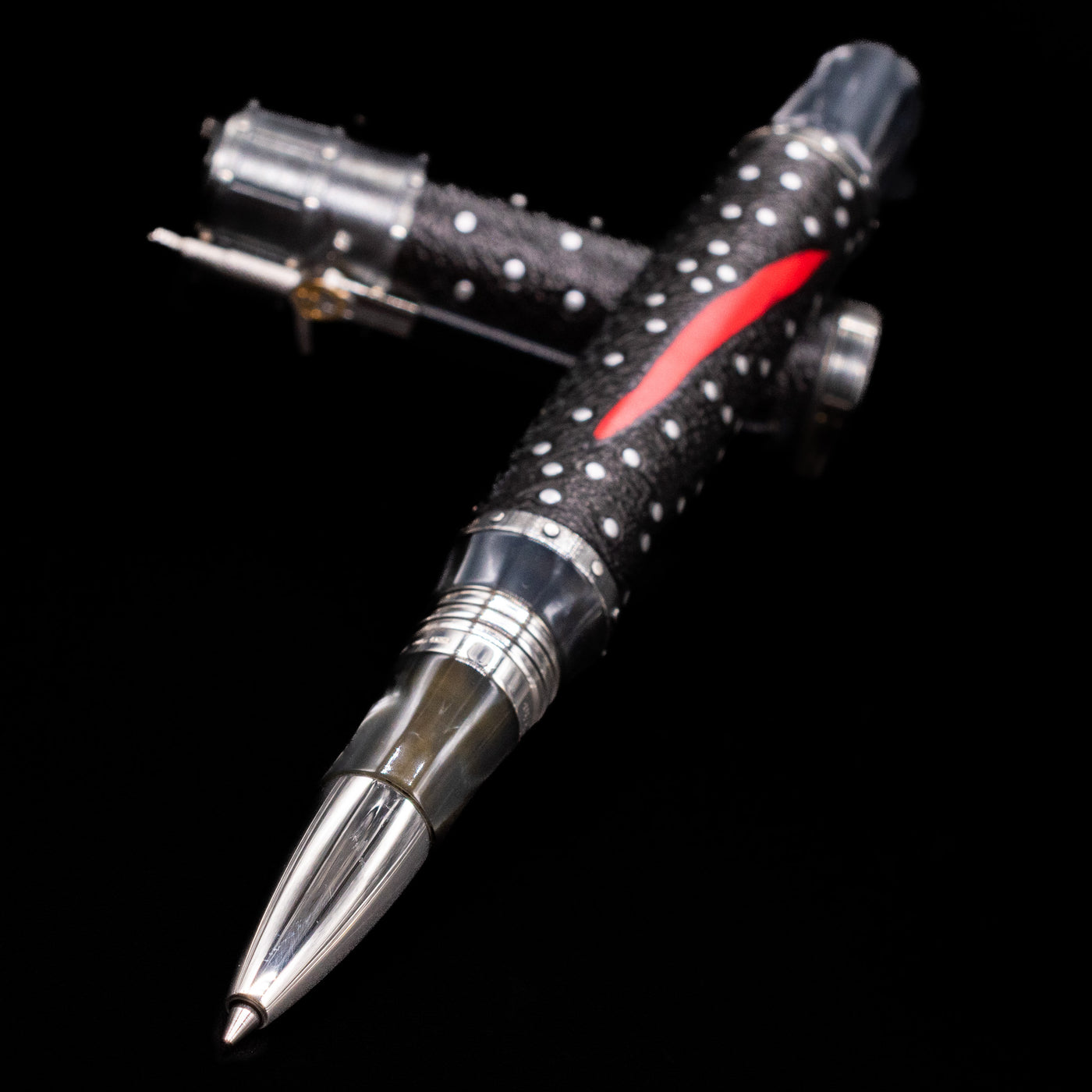 Montegrappa The Witcher: Mutation Rollerbal Pen laying across its own cap, crossed, with a focus on the tip.