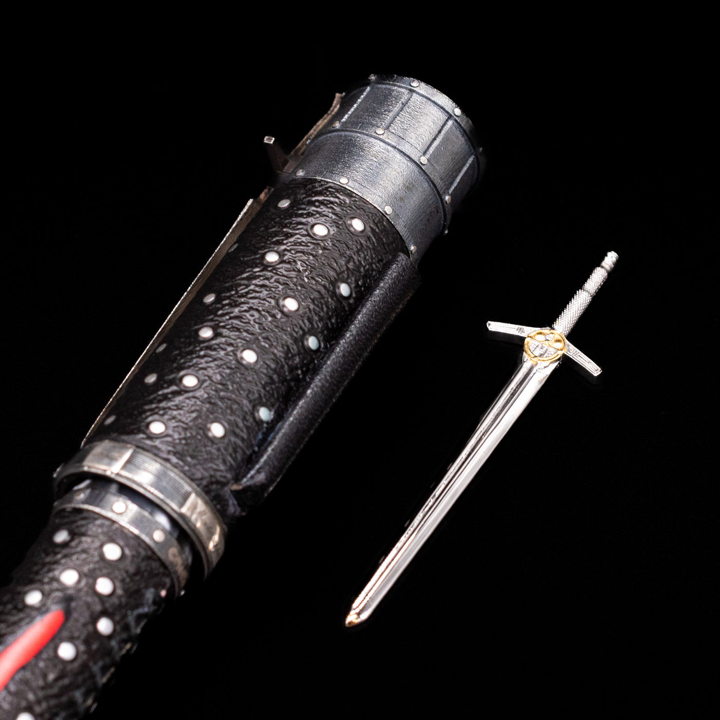 A detailed view of the sword unsheathed and laying next to the Montegrappa The Witcher: Mutation Rollerbal Pen.