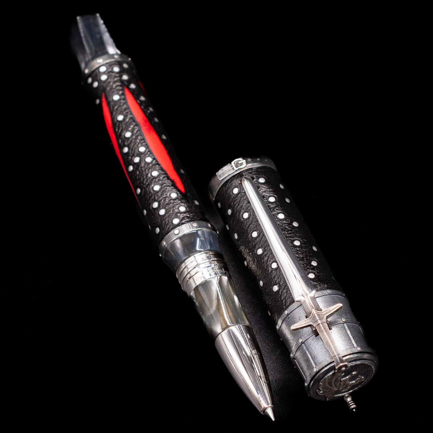  A full view of the Montegrappa The Witcher: Mutation Rollerbal Pen uncapped, with its cap laying next to the pen. 