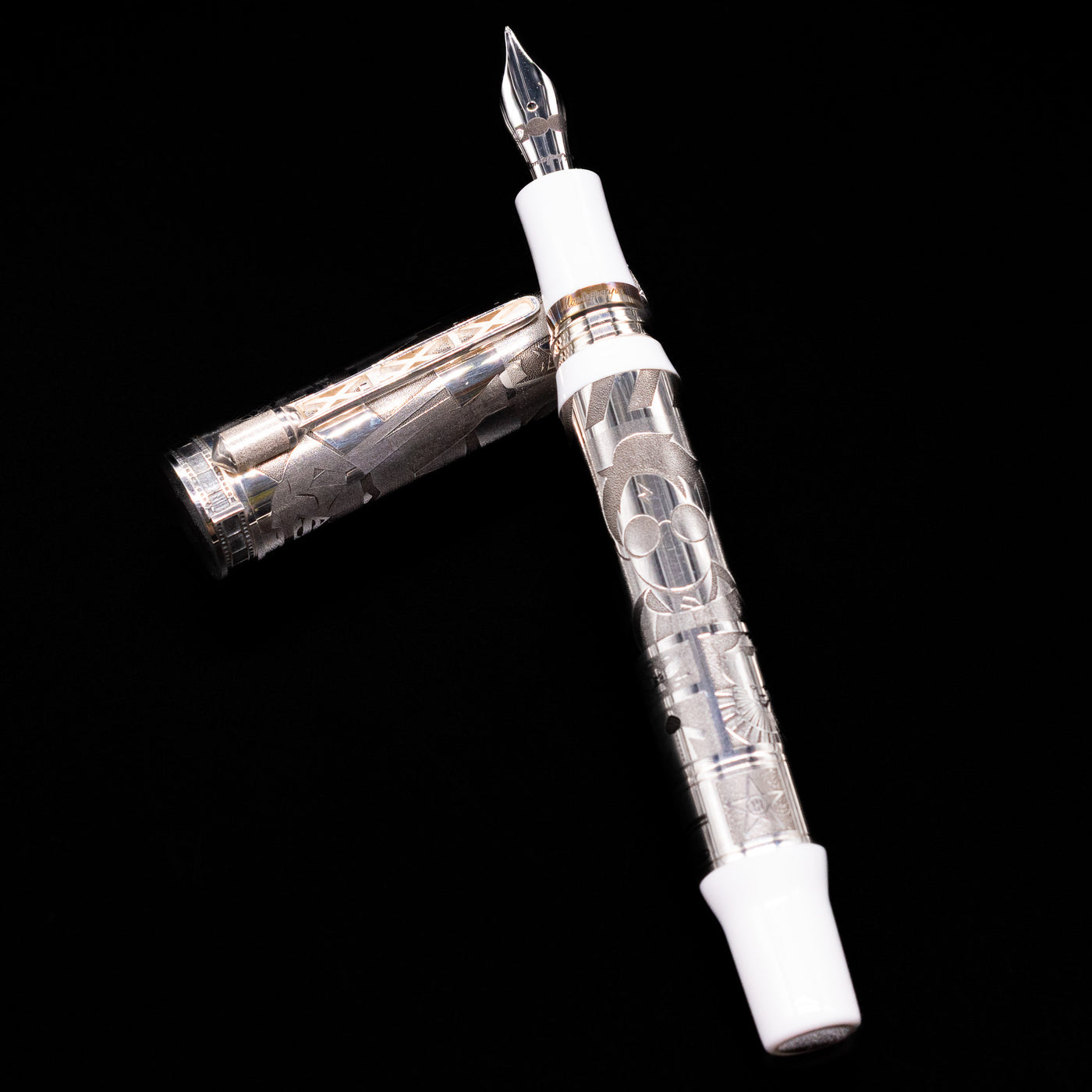 Montegrappa Warner Brothers 100th Anniversary Fountain Pen laying on top of its cap in a crossed position showing full view of the entire uncapped pen.