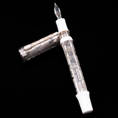 Montegrappa Warner Brothers 100th Anniversary Fountain Pen laying on top of its cap in a crossed position showing full view of the entire uncapped pen.