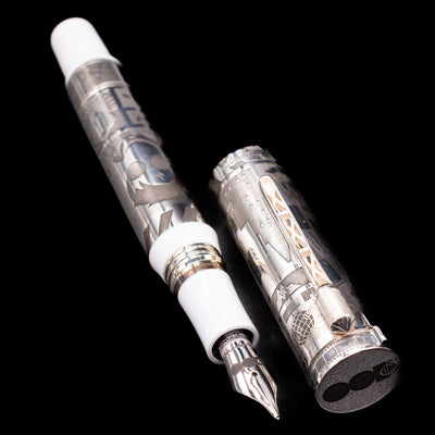  A full view of the Montegrappa Warner Brothers 100th Anniversary Fountain Pen uncapped, with its cap laying next to the pen. 