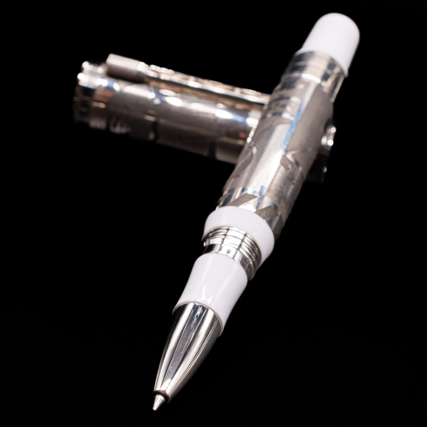 Montegrappa Warner Brothers 100th Anniversary Rollerball Pen laying across its own cap, crossed, with a focus on the tip.