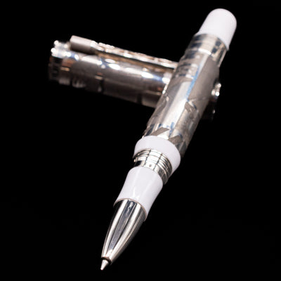 Montegrappa Warner Brothers 100th Anniversary Rollerball Pen laying across its own cap, crossed, with a focus on the tip.