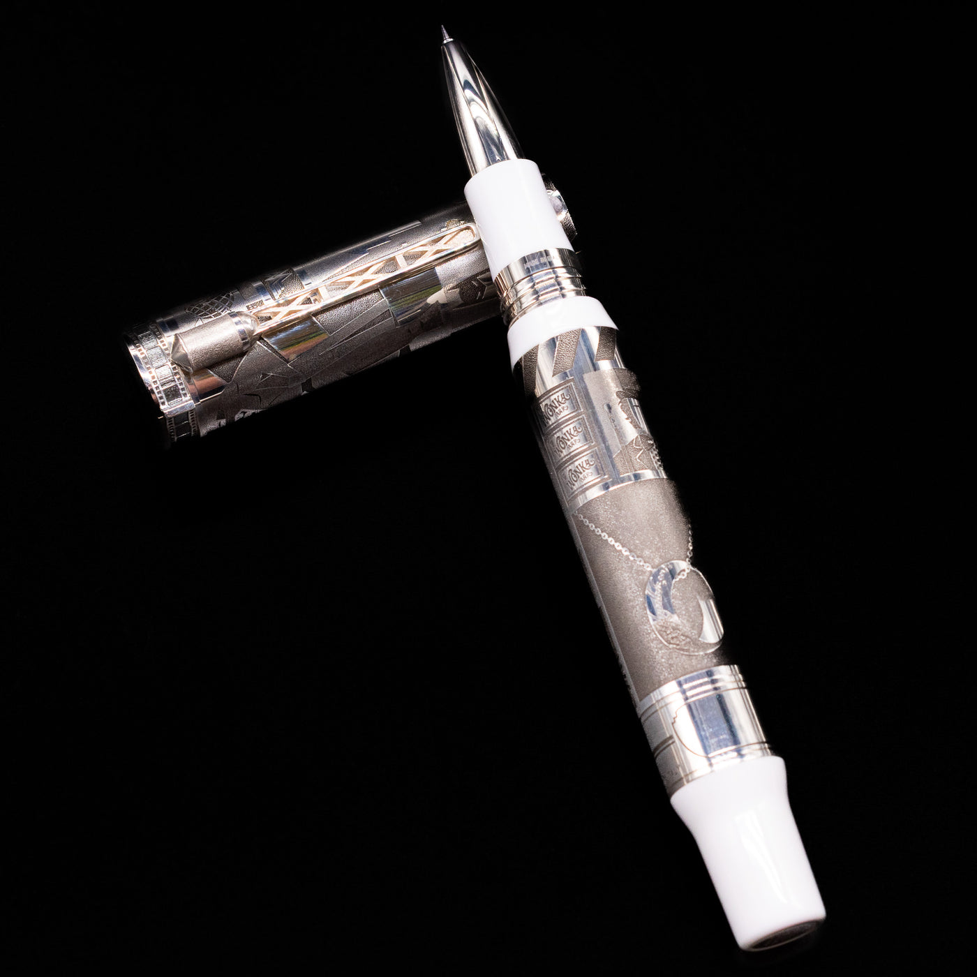 Montegrappa Warner Brothers 100th Anniversary Rollerball Pen laying across its own cap, crossed, with a focus on the tip.