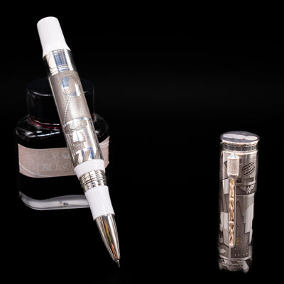 Montegrappa Warner Brothers 100th Anniversary Rollerball Pen leaning on an ink bottle uncapped showcasing the detailing on the nib.