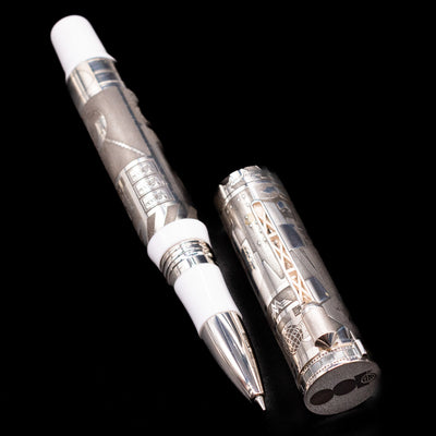 A full view of the Montegrappa Warner Brothers 100th Anniversary Rollerball Pen uncapped, with its cap laying next to the pen. 