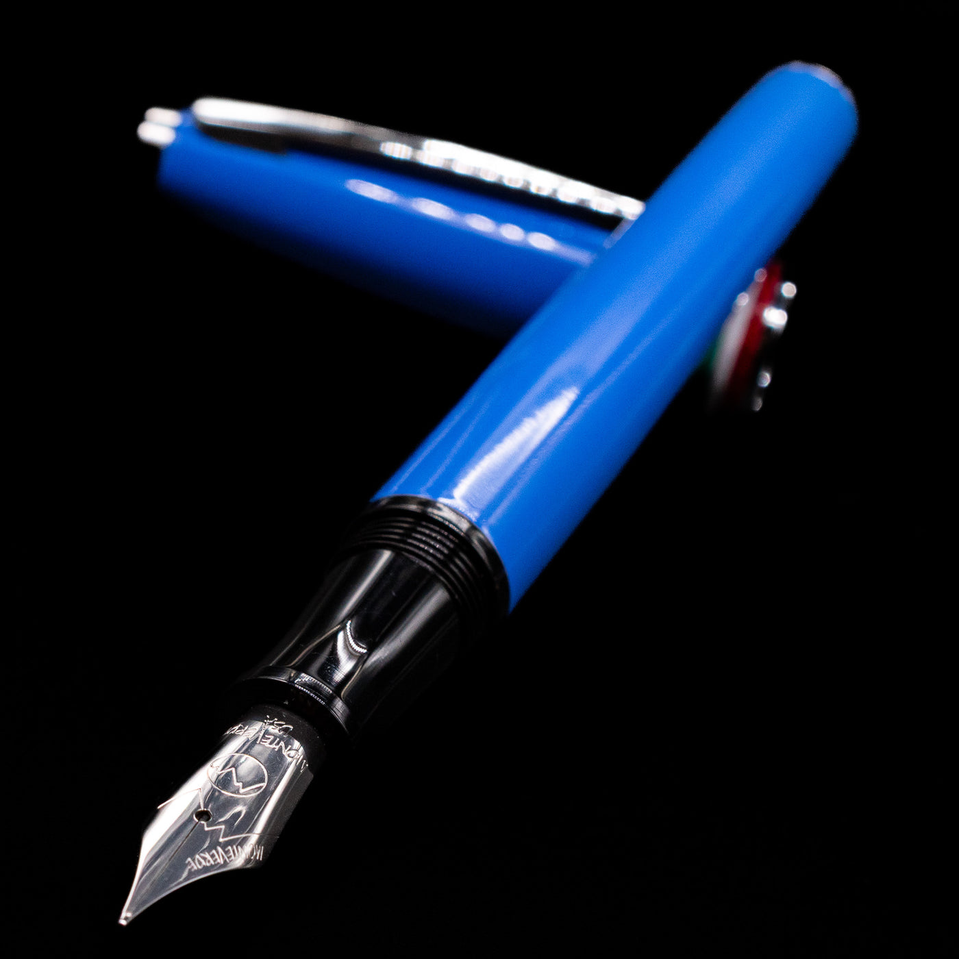 Monteverde Aldo Domani Italia Fountain Pen - Exotic Blue laying across its own cap, crossed, with a focus on the nib.