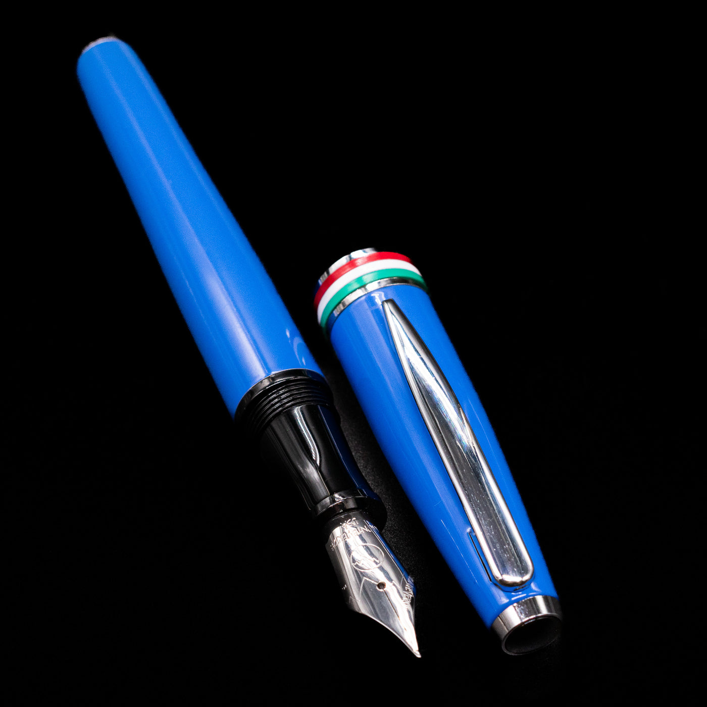 A full view of the Monteverde Aldo Domani Italia Fountain Pen - Exotic Blue uncapped, with its cap laying next to the pen. 