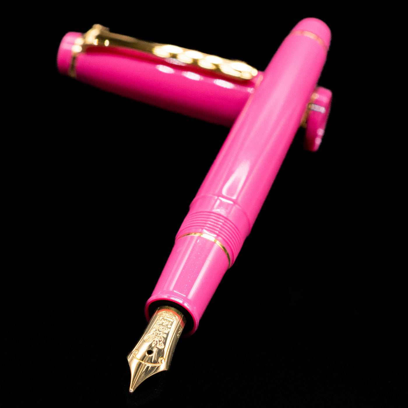 Nagasawa Original Fountain Pen - Suma-Rikyu Rose laying across its own cap, crossed, with a focus on the nib.