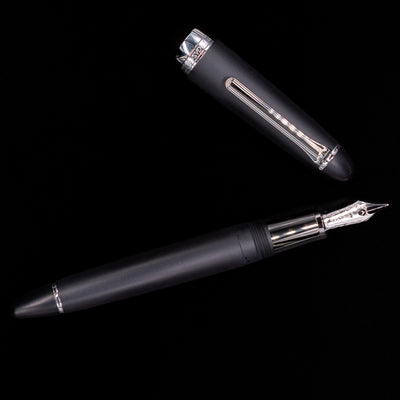 An overhead view of the Nagasawa Original Large Fountain Pen - Black & Silver FL (For Lawyer) uncapped.