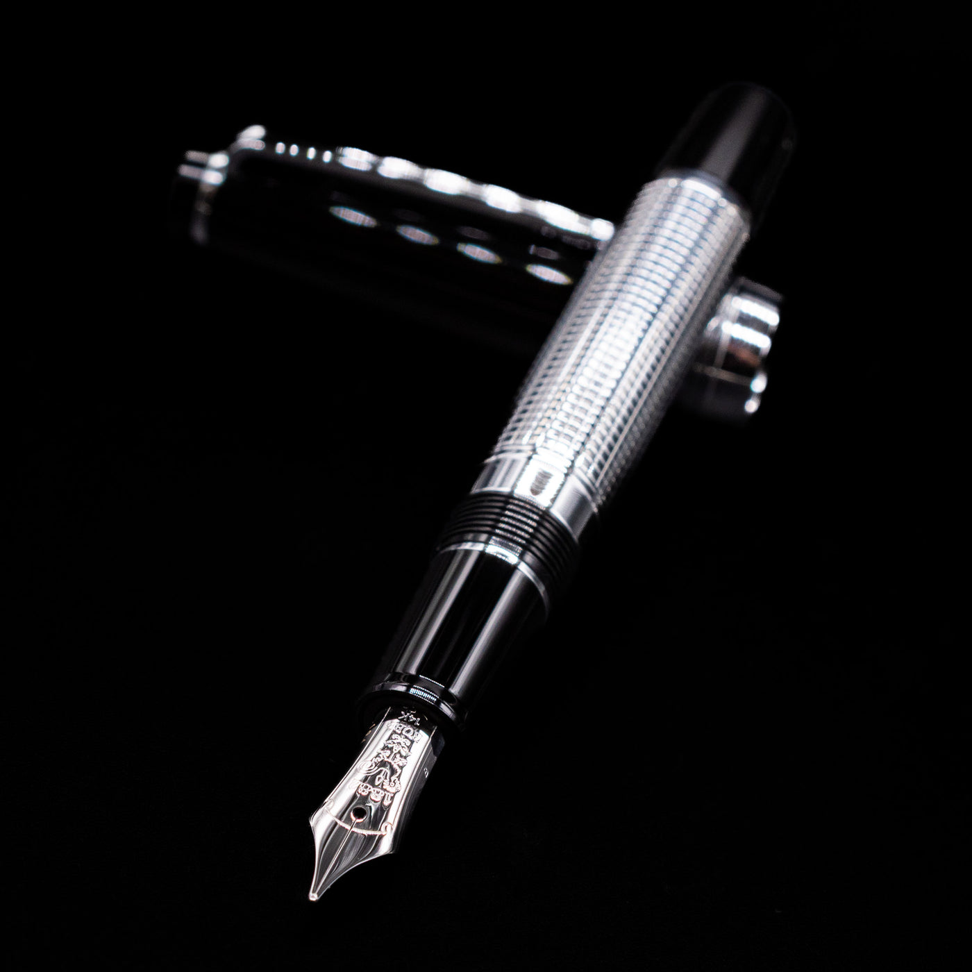 Nagasawa Original Limited Edition Fountain Pen - Engrave Kou laying across its own cap, crossed, with a focus on the nib.